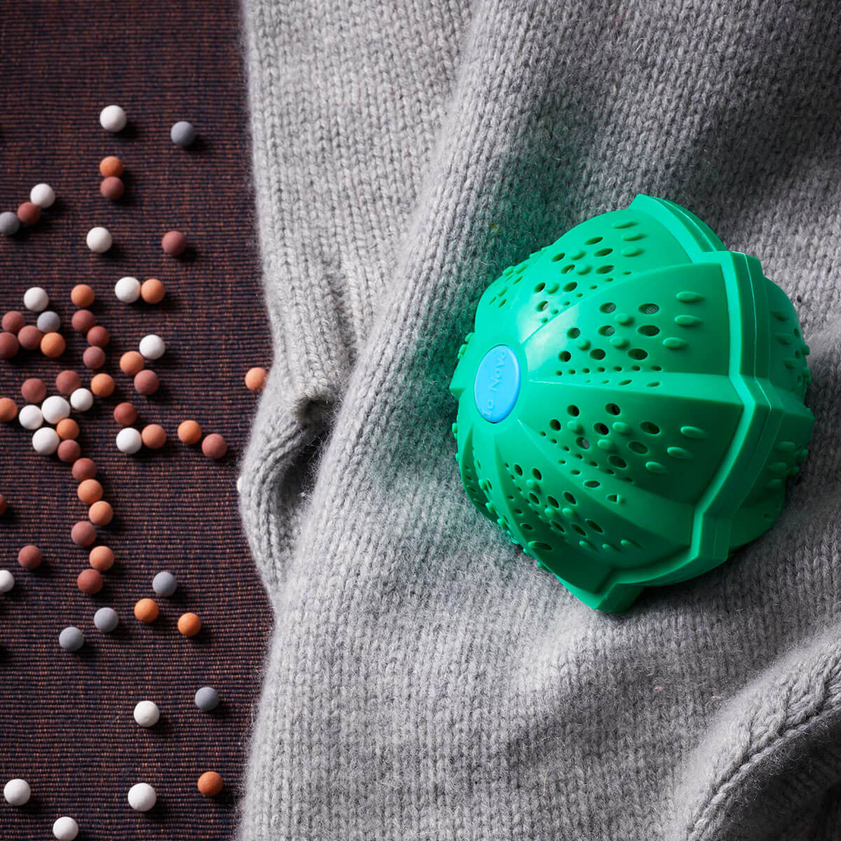 Eco Waschball von Io Nova liegt auf grauem Cashmere Pullover