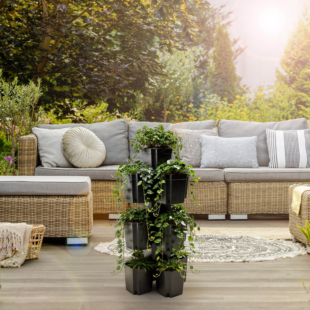 FlexiFlora modulares Pflanzsystem als platzsparende Pflanzsäule mit Pflanzen auf einer gemütlichen Terrasse.